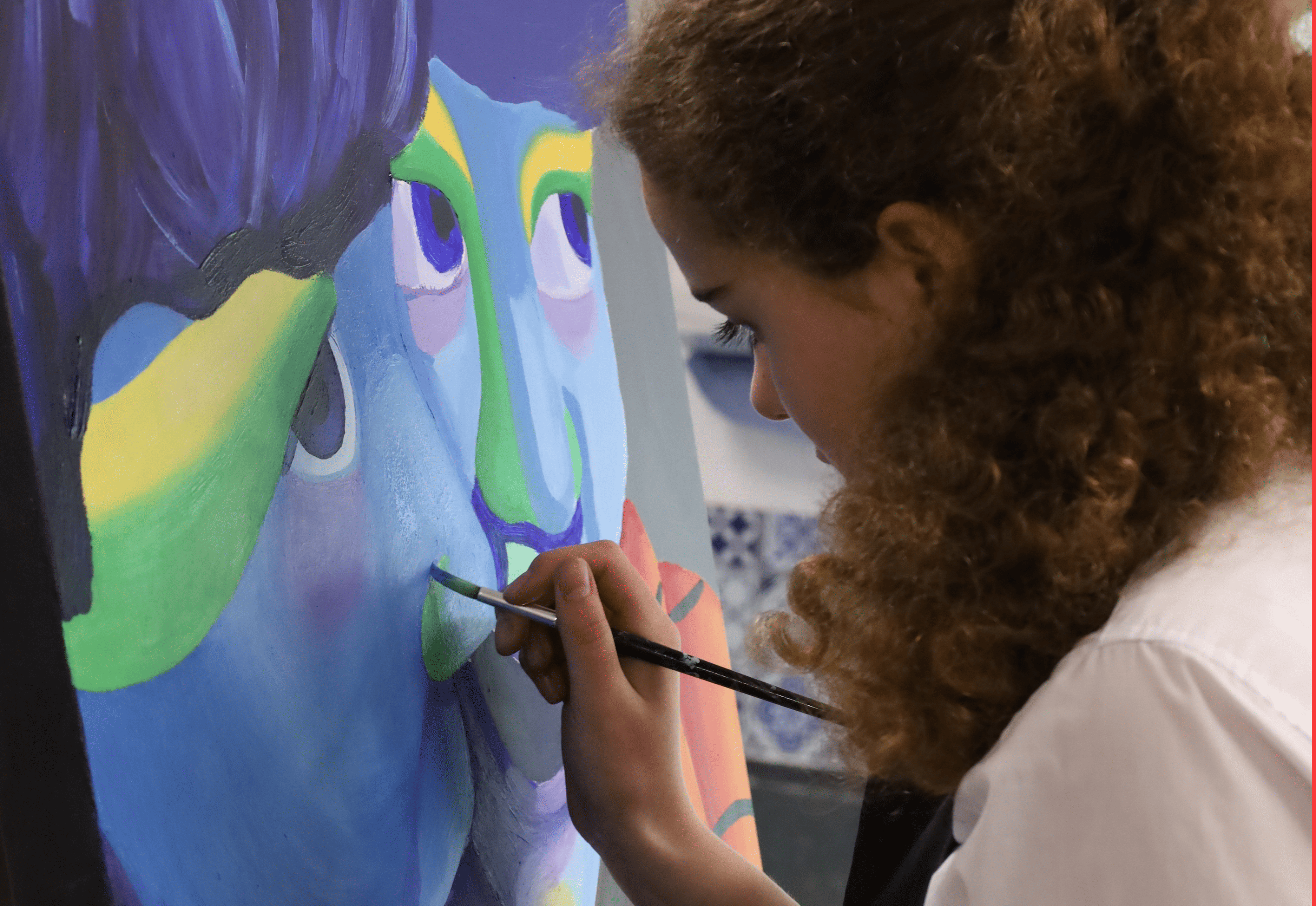 Pupil creating an art piece through paint