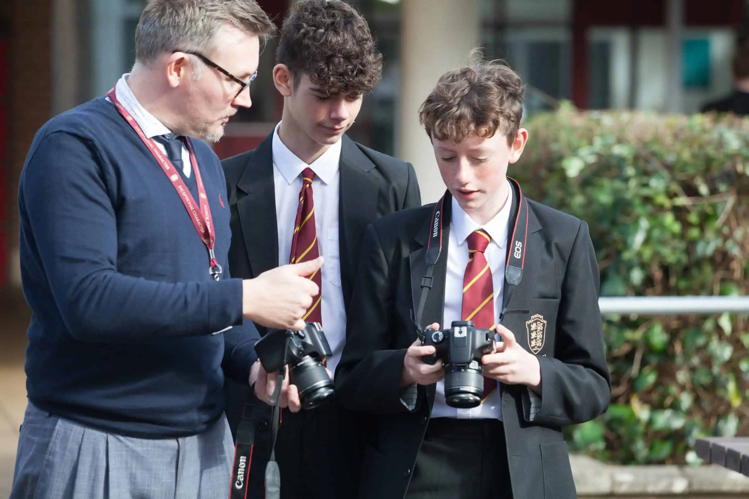 Students learning photography skills with teacher guidance at Kings School, Hampshire campus.