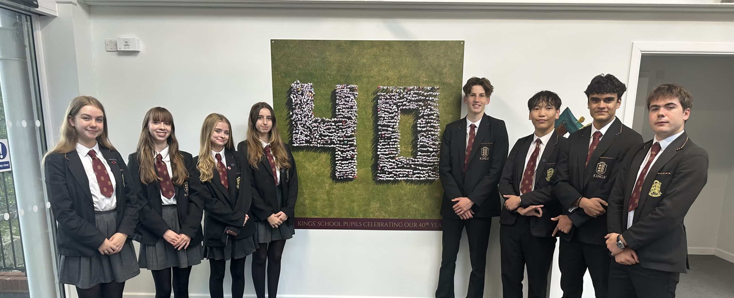 Young students in uniform standing together in a school corridor.
