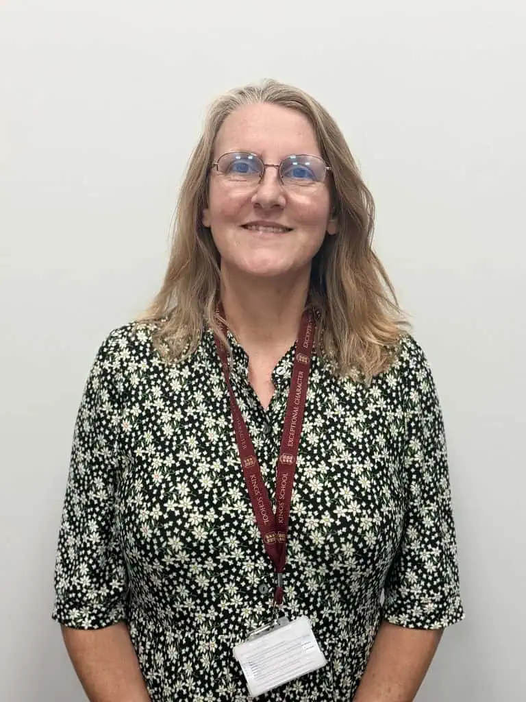 Female governor at Kings School with lanyard and glasses.
