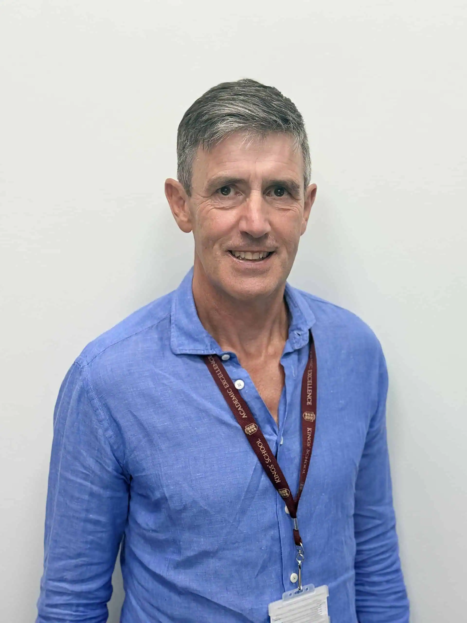 School governor at Kings School in Hants, wearing a blue shirt and lanyard.