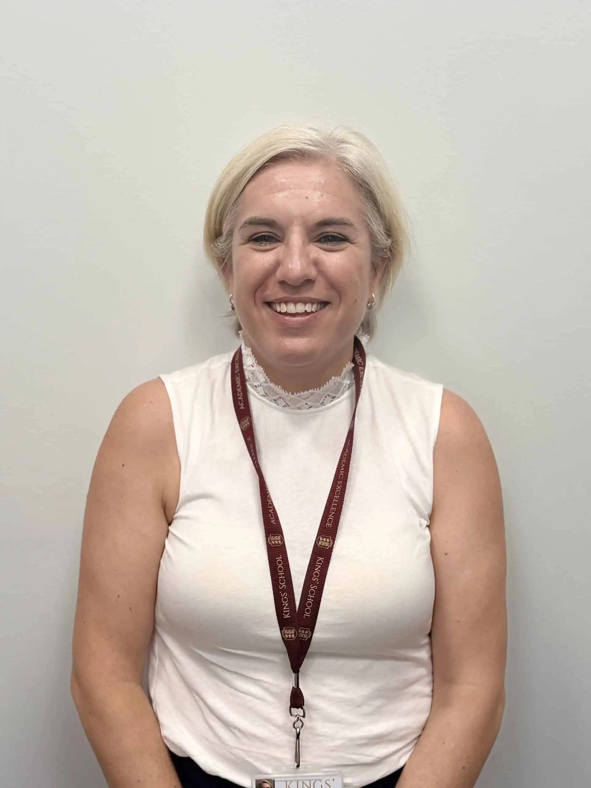 Smiling female governor at Kings School with lanyard.